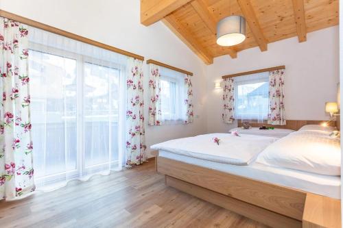 um quarto com uma cama grande e uma janela grande em Ferienhaus Monika em Leogang