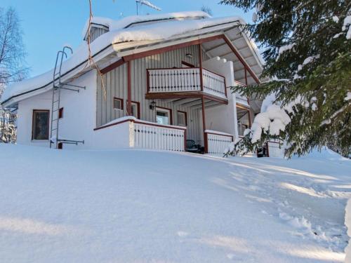 a house covered in snow in front of it at Holiday Home Hallantytär a2 paritalo by Interhome in Hyrynsalmi