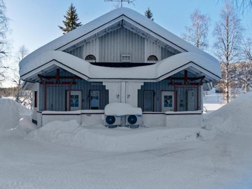ein schneebedecktes Haus mit einem Schneehaufen in der Unterkunft Holiday Home Hallantytär a2 paritalo by Interhome in Hyrynsalmi