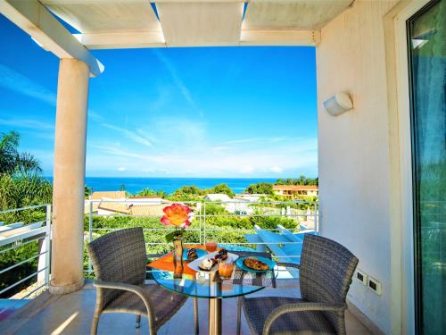 un tavolo e sedie su un balcone con vista sull'oceano di Villa Bianca by Interhome ad Alcamo Marina