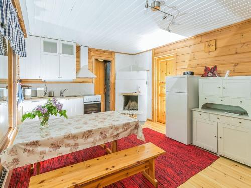 a kitchen with a table and a refrigerator at Holiday Home Ahven by Interhome in Hiukkajoki