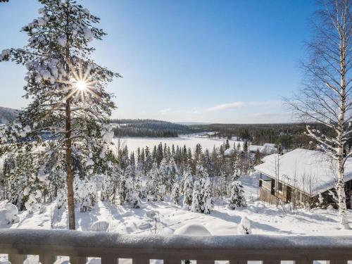 une cour enneigée avec un arbre et une maison dans l'établissement Holiday Home Aurinkoalppi 12a paritalo by Interhome, à Hyrynsalmi