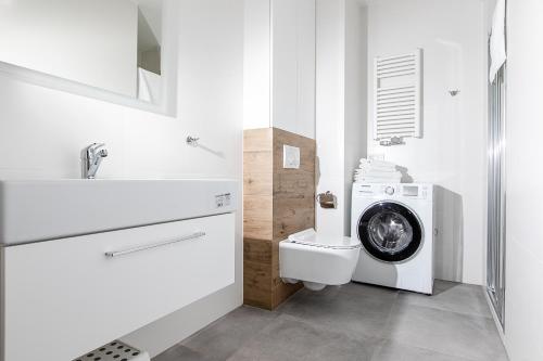 un bagno con lavatrice accanto a servizi igienici di Resort Apartamenty Klifowa Rewal 44 a Rewal