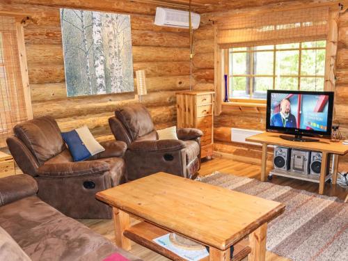 ein Wohnzimmer mit Sofas und Fernseher in einer Blockhütte in der Unterkunft Holiday Home Lampitaival 5 by Interhome in Kotila