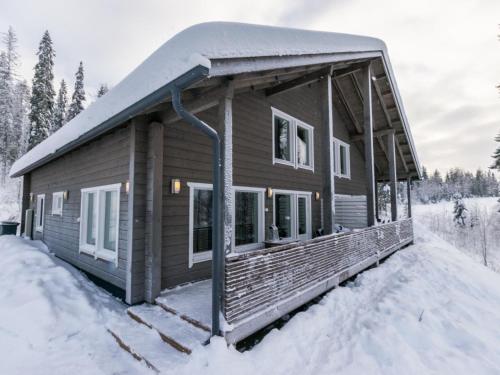 a log cabin with snow on the porch at Holiday Home Vihtarinne b paritalo by Interhome in Hyrynsalmi