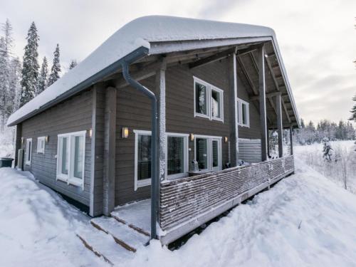 eine Blockhütte mit Schnee auf der Veranda in der Unterkunft Holiday Home Vihtarinne b paritalo by Interhome in Hyrynsalmi