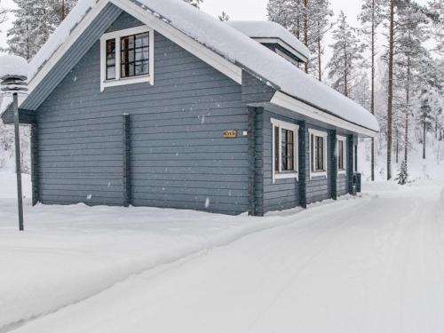 een blauw huis met sneeuw op de grond bij Holiday Home Ilves by Interhome in Kotila