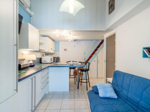 Il comprend une cuisine et un salon avec un canapé bleu. dans l'établissement Holiday Home Les Patios de La Mer by Interhome, à Saint-Cyprien