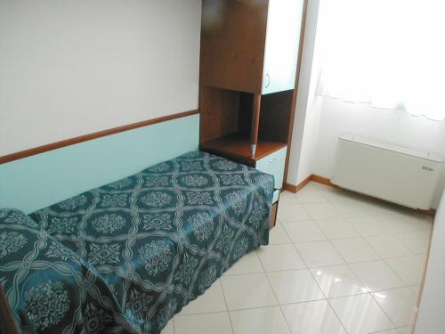 a bedroom with a bed with a blue comforter at Residence Oltremare in San Benedetto del Tronto