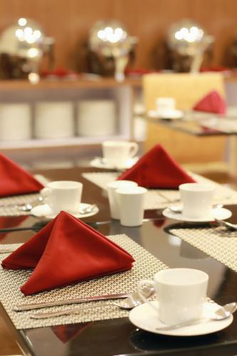 a table with red napkins and dishes on it at Nueve Malioboro Hotel Yogyakarta in Yogyakarta