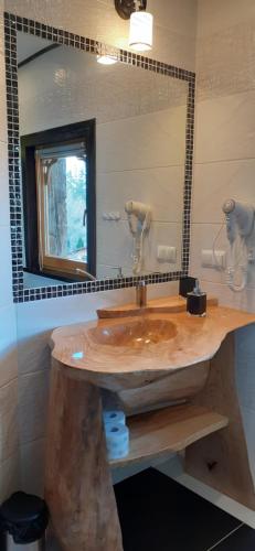a bathroom with a wooden sink and a mirror at Domki u Bobaków in Ząb