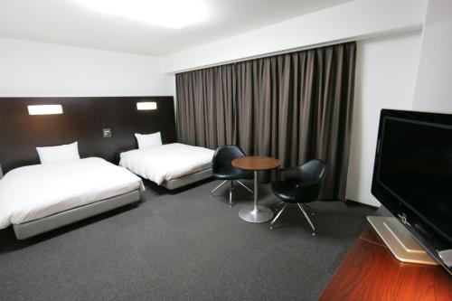 Green Rich Hotel Suizenji tesisinde bir odada yatak veya yataklar