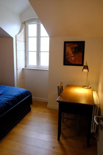a bedroom with a desk and a bed and a window at Le Villemarais, site d'exception in La Rochelle