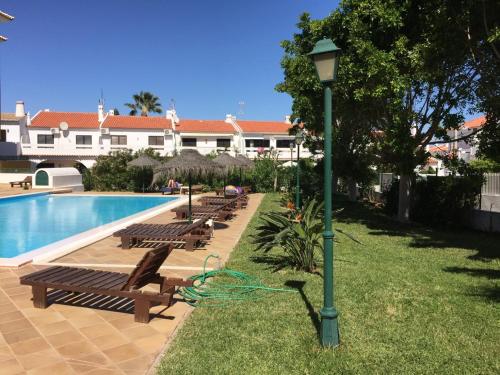 a row of benches next to a pool with a light pole at T1 Altura, Piscina Terraço Prestige For Home in Altura