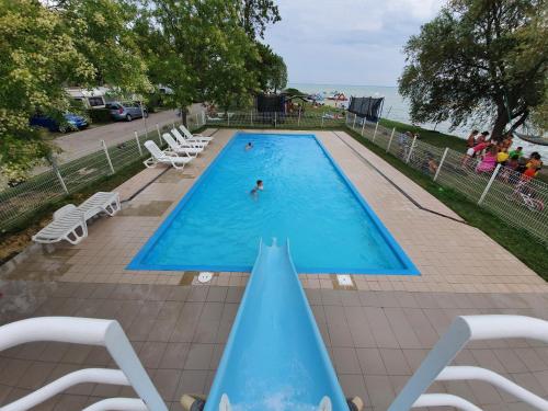 a swimming pool with a person in the water at NaturExpert Mobil házak-Pelso Kemping Alsóörs in Alsóörs