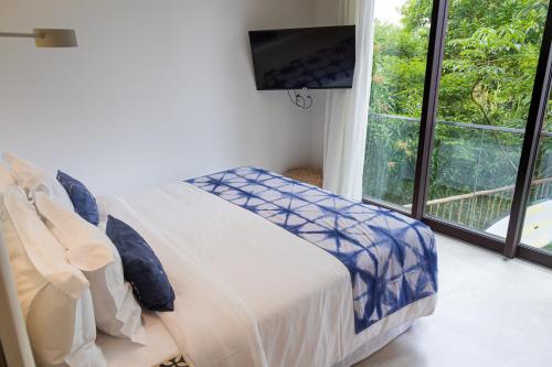 a bedroom with a bed and a large window at Wyndham Ilhabela Casa Di Sirena in Ilhabela