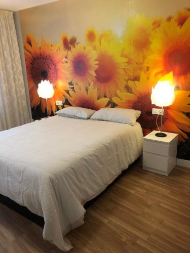 a bedroom with a bed with flowers on the wall at EL RAMILLETE in Soria