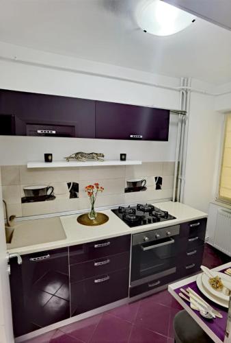 a kitchen with a stove and a vase of flowers at Central Apartament in Iaşi