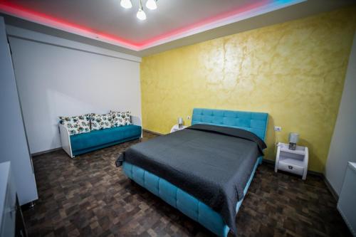 a bedroom with a blue bed and a couch at Cazare Gallamar in Bîrlad