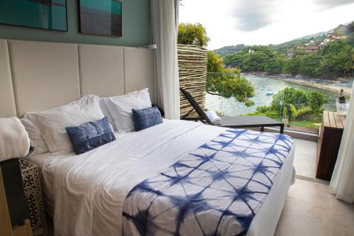a bedroom with a bed with a view of a river at Wyndham Ilhabela Casa Di Sirena in Ilhabela