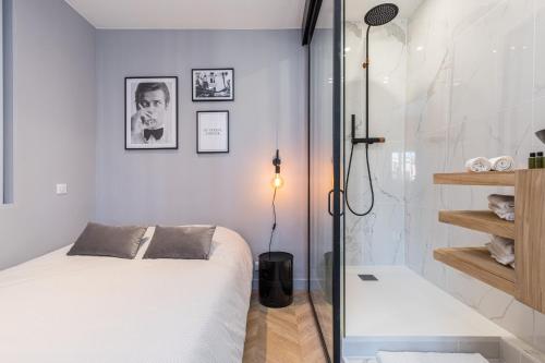 een slaapkamer met een bed en een glazen douche bij SMARTBNB - Dernier etage Ascenseur - 1 min Plage et Zone Pietonne in Nice