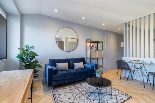 un salon avec un canapé bleu et un miroir dans l'établissement 1 SU EDE - Dernier etage Ascenseur - 1 min Plage et Zone Pietonne, à Nice