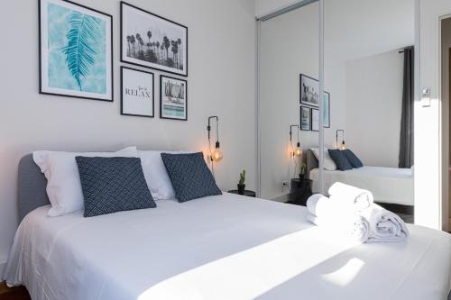 - une chambre blanche avec un grand lit blanc et des oreillers bleus dans l'établissement 7 MEDECIN - Place Massena - Central 2p - Lumineux - Climatise, à Nice