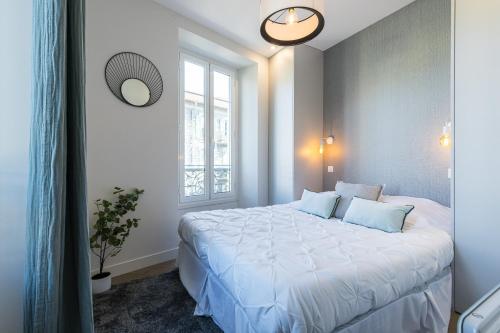 une chambre avec un grand lit blanc avec une fenêtre dans l'établissement 2 BAVASTRO - Beau 2 pieces lumineux et cosy - Climatise, à Nice