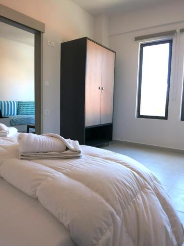 a bedroom with a large white bed with a window at Amaryllis in Plataniás