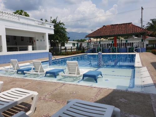 une grande piscine avec des chaises et un bâtiment dans l'établissement Hotel Maratea Melgar, à Melgar