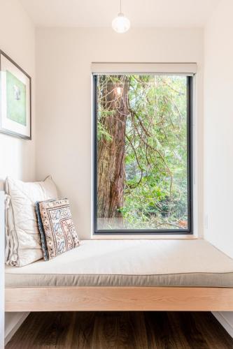 a window seat in a room with a tree at Storm Cove Suites in Ucluelet