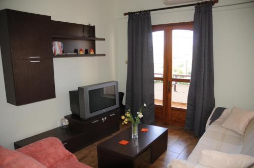 a living room with a couch and a tv at Ekavi Apartments in Sitia