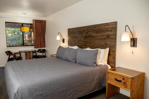 a bedroom with a bed with a wooden headboard and a table at Eagle Cap Chalets in Joseph