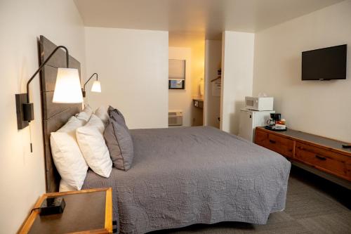 a bedroom with a bed and a flat screen tv at Eagle Cap Chalets in Joseph