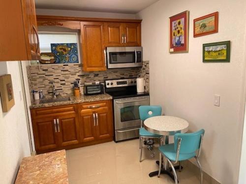 a kitchen with a table and chairs and a stove and microwave at Rim Canal Cottage 'Yellow House' with Canal Views & Boat Dock cottage in Okeechobee
