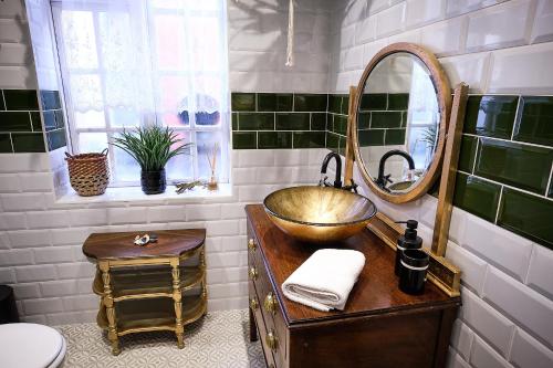 a bathroom with a gold sink and a mirror at The Emerald Suite by Margate Suites in Margate