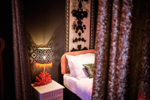 a bedroom with a bed and a table with a lamp at The Emerald Suite by Margate Suites in Margate