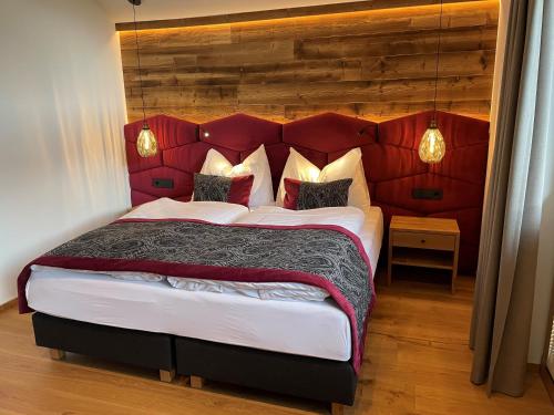a bedroom with a large bed with a red headboard at Ferienlodge Edelstein in Forstau