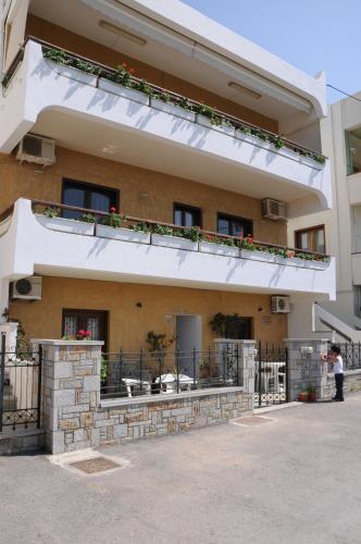 a building with a balcony with flowers on it at Ekavi Apartments in Sitia
