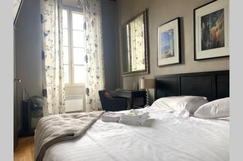 une chambre avec un grand lit blanc et une fenêtre dans l'établissement 18 Garibaldi, à Nice
