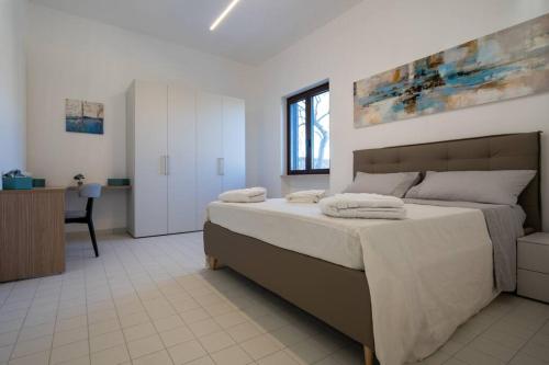 1 dormitorio con 1 cama grande y escritorio en Elegante Villa tra Mare e Storia, en Paestum