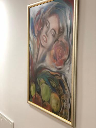 a painting of a woman with fruit on a wall at TEPIĆ Garni Hotel in Temerin