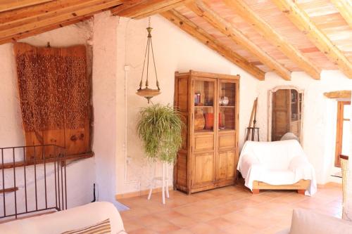 a living room with a wooden cabinet and a table at Ca la Pasita 26 in Beniali