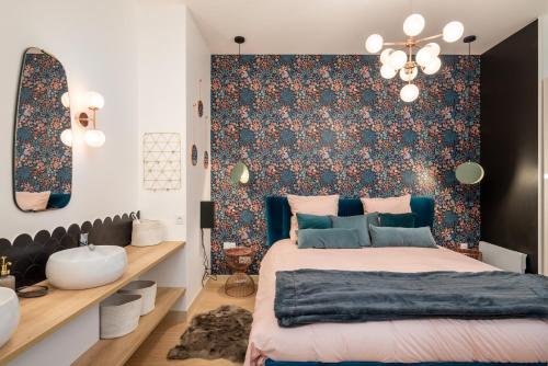 um quarto com uma cama e uma parede com um papel de parede floral em Le Cocon Hygge & SPA em Lyon