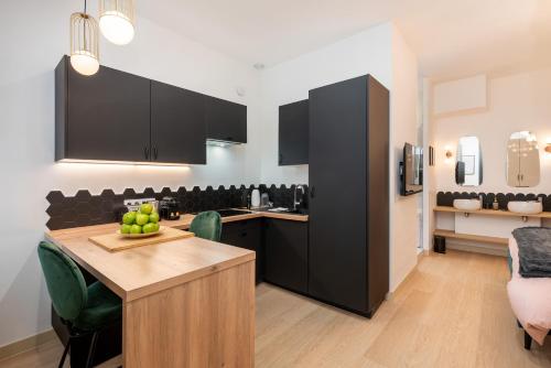 uma cozinha com armários pretos e uma mesa com fruta em Le Cocon Hygge & SPA em Lyon