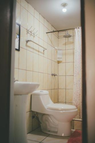 a bathroom with a toilet and a sink at Hotel Excalibur in Lima
