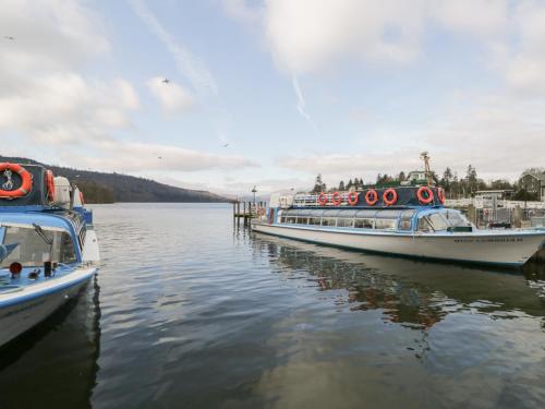 two boats docked at a dock on the water at St Mary's Cottage in Windermere