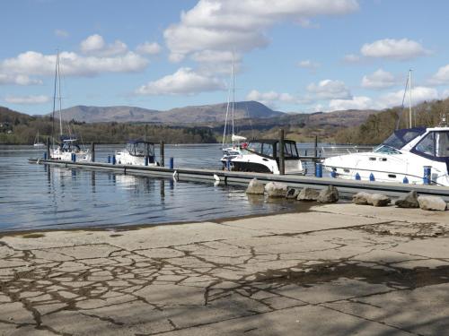 a group of boats docked at a dock in the water at St Mary's Cottage in Windermere