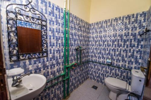 a bathroom with a sink and a toilet and a mirror at Les Jardins De Todgha gorges de todra tinghir in Aït Baha