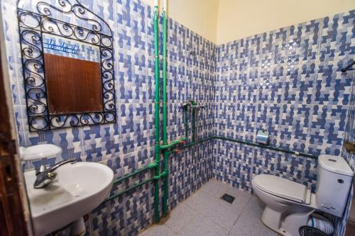 a bathroom with a sink and a toilet and a mirror at Les Jardins De Todgha gorges de todra tinghir in Aït Baha